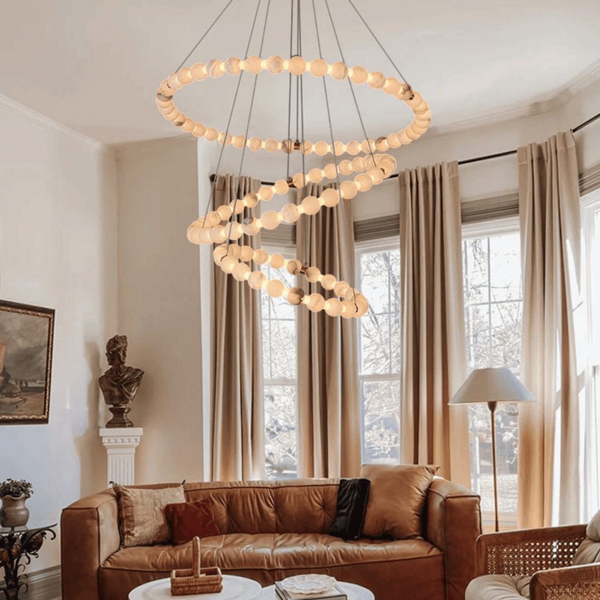 Living room with a modern chandelier, brown sofa, and large windows.