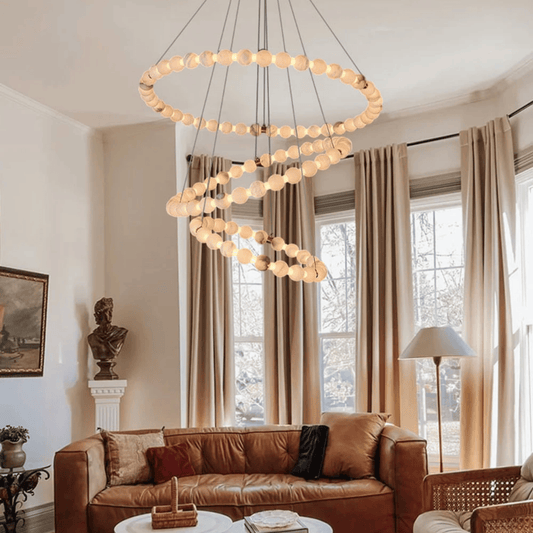 Living room with a modern chandelier, brown sofa, and large windows.