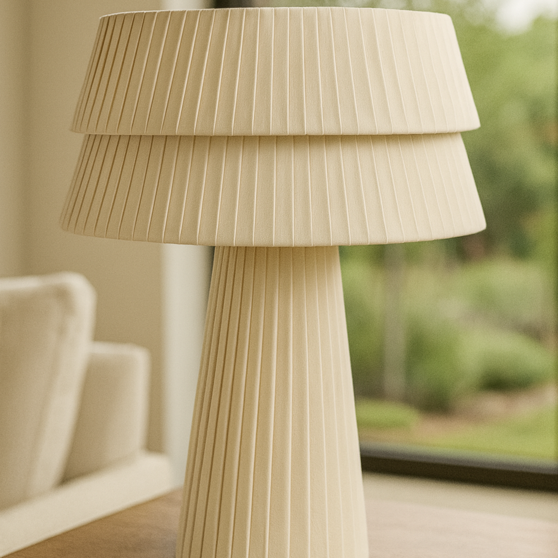Beige pleated lamp on a wooden surface with a blurred background