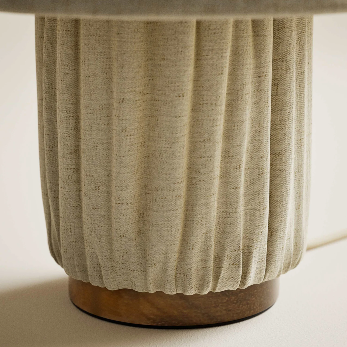 Close-up of a textured ceramic vase with a ribbed design on a neutral background