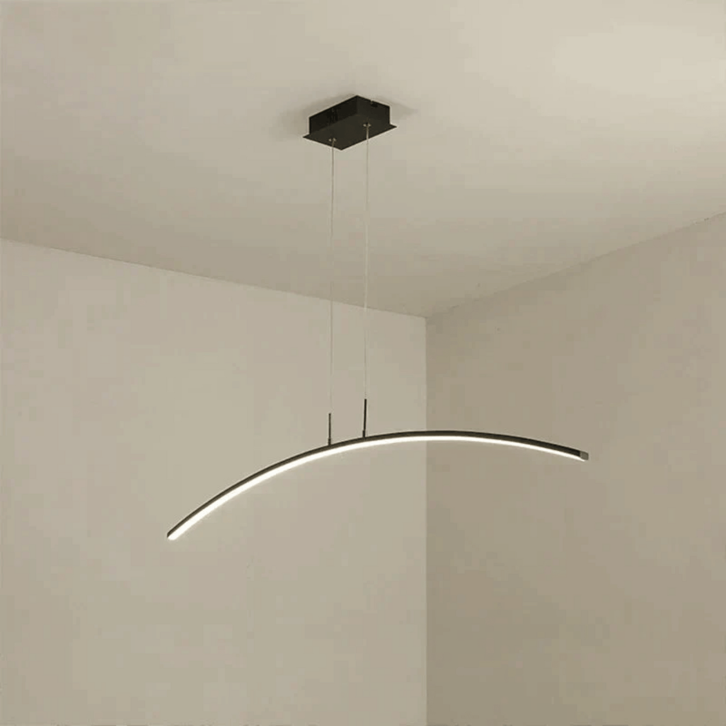 Modern pendant light fixture hanging from the ceiling in a minimalistic room.