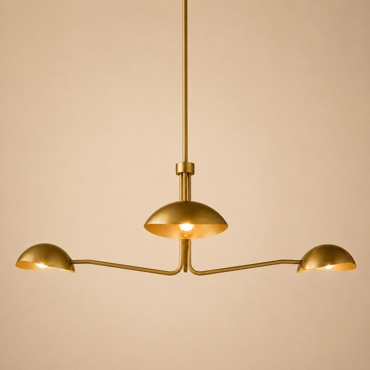 Gold chandelier with three arms on a beige background