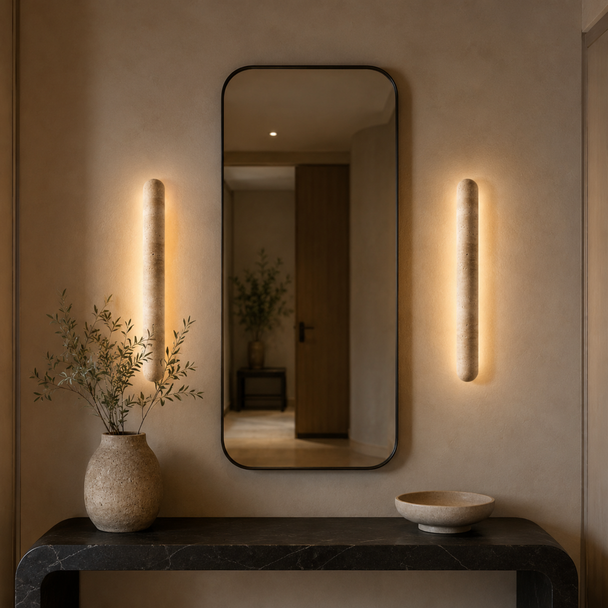 Modern interior with a mirror, wall lights, and decorative items on a console table.
