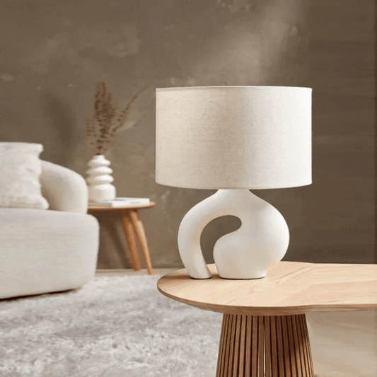 White table lamp on a wooden side table in a living room setting