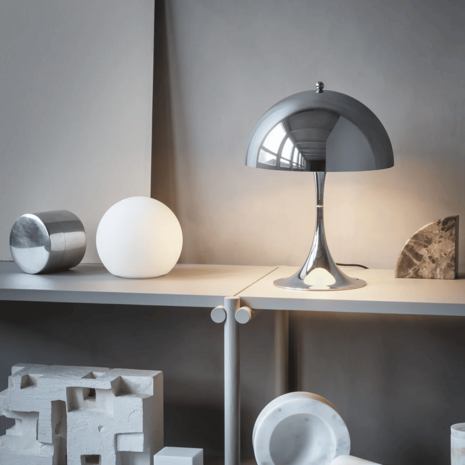 Modern table lamp on a desk with decorative items in a minimalistic setting