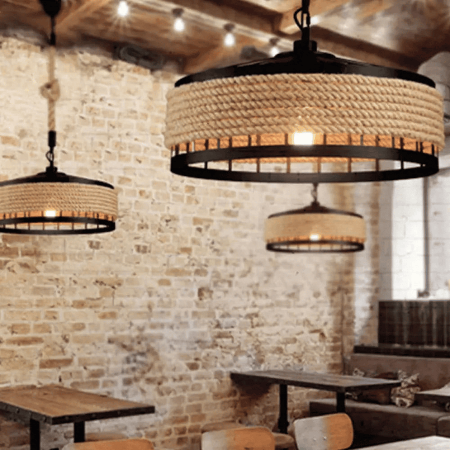 Rustic pendant lights hanging in a restaurant with stone walls and wooden tables.