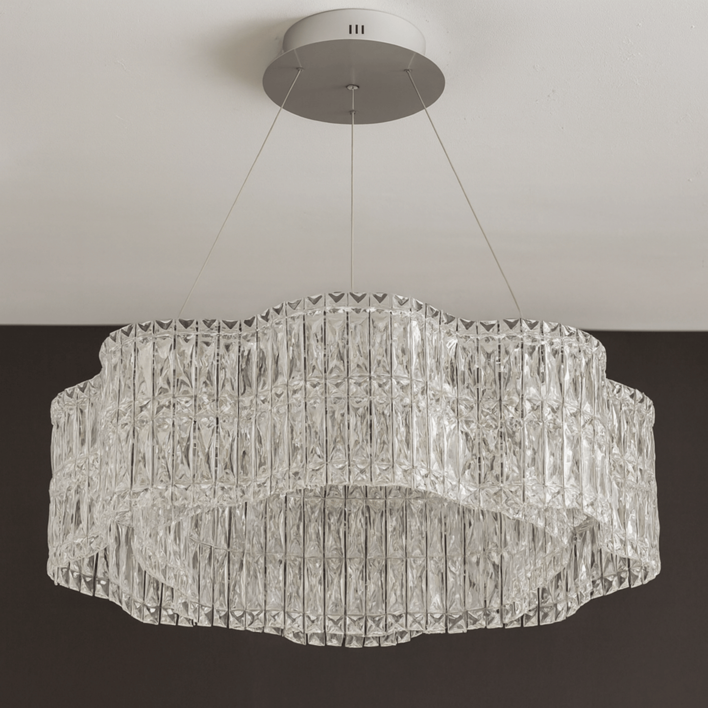 Crystal chandelier hanging from the ceiling against a neutral background