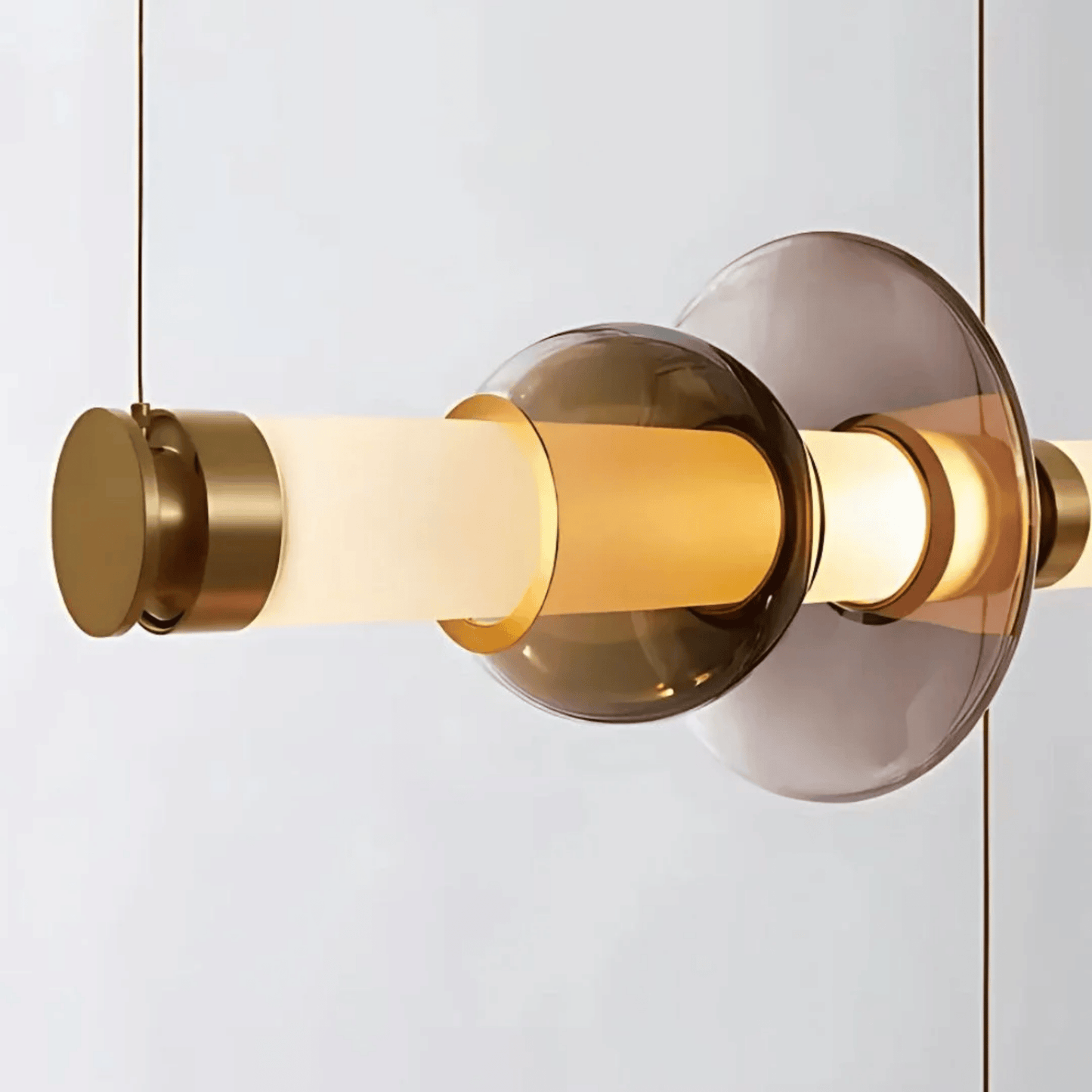 Modern pendant light with gold and glass design on a white background