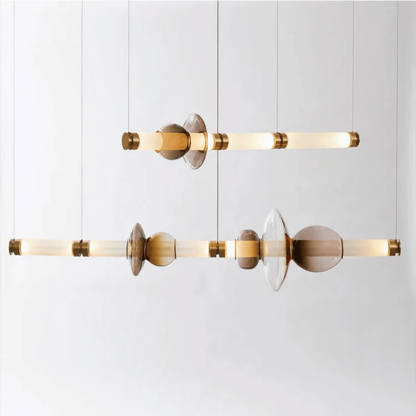 Modern pendant light with gold and smoked glass design on a white background