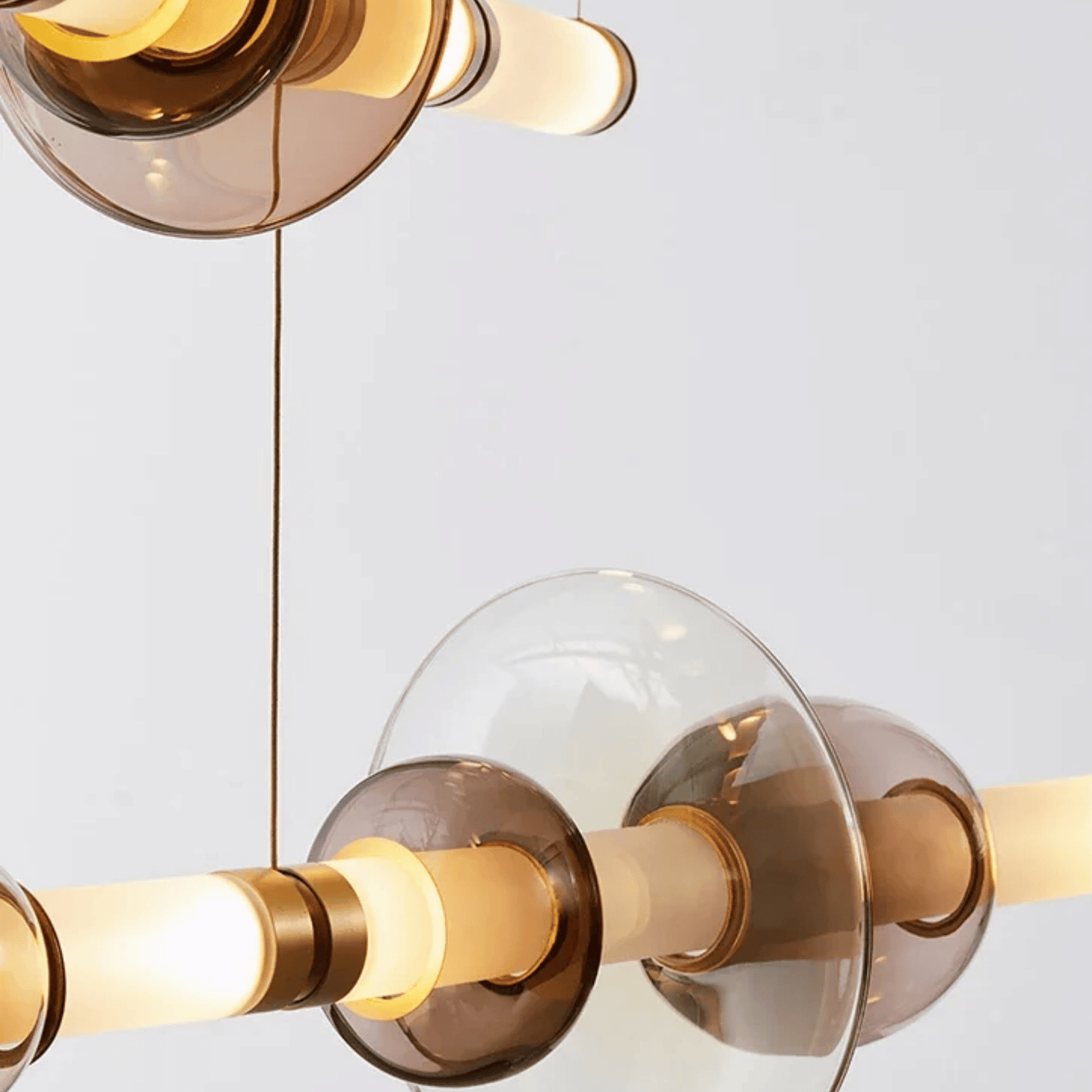 Modern chandelier with gold and glass design on a light gray background