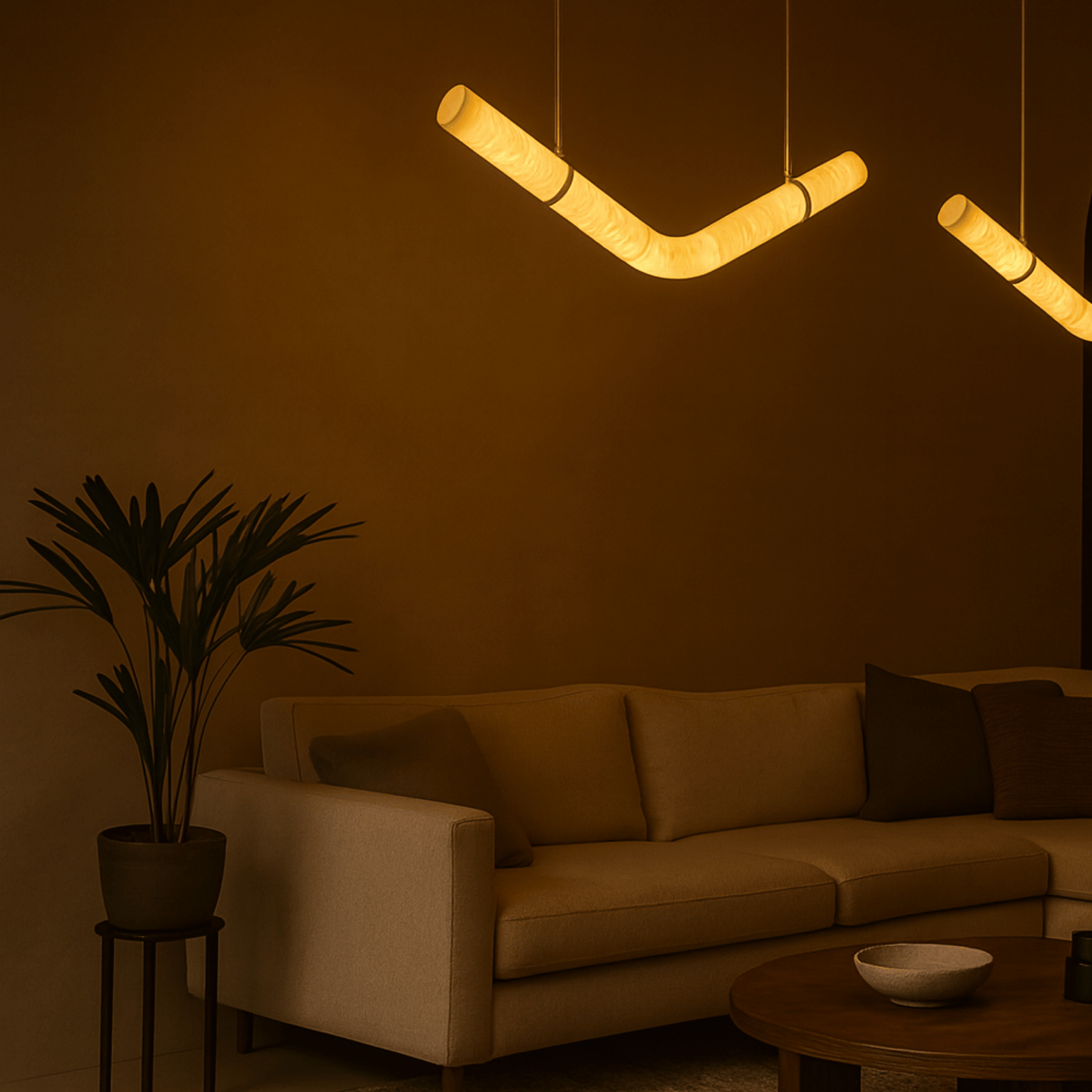 Modern living room with a beige sofa, plant, and unique pendant light fixture.