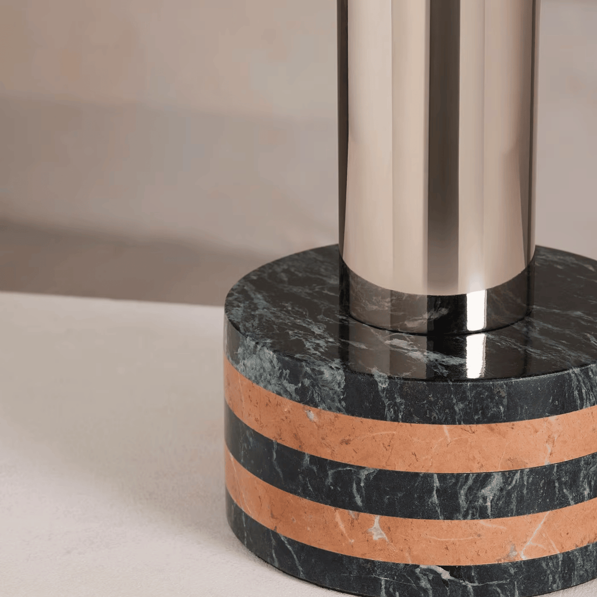 Marble base with metallic column on a neutral background