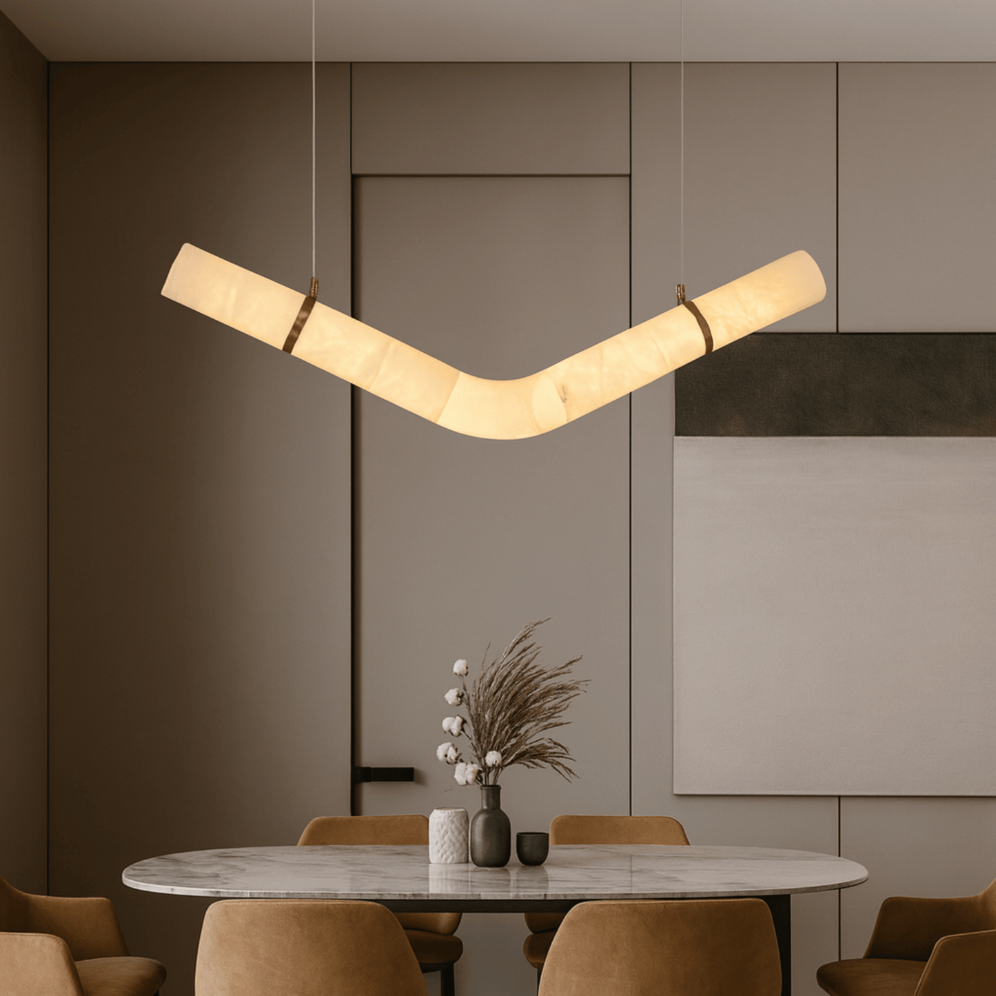 Modern pendant light hanging above a dining table with chairs in a stylish interior setting.