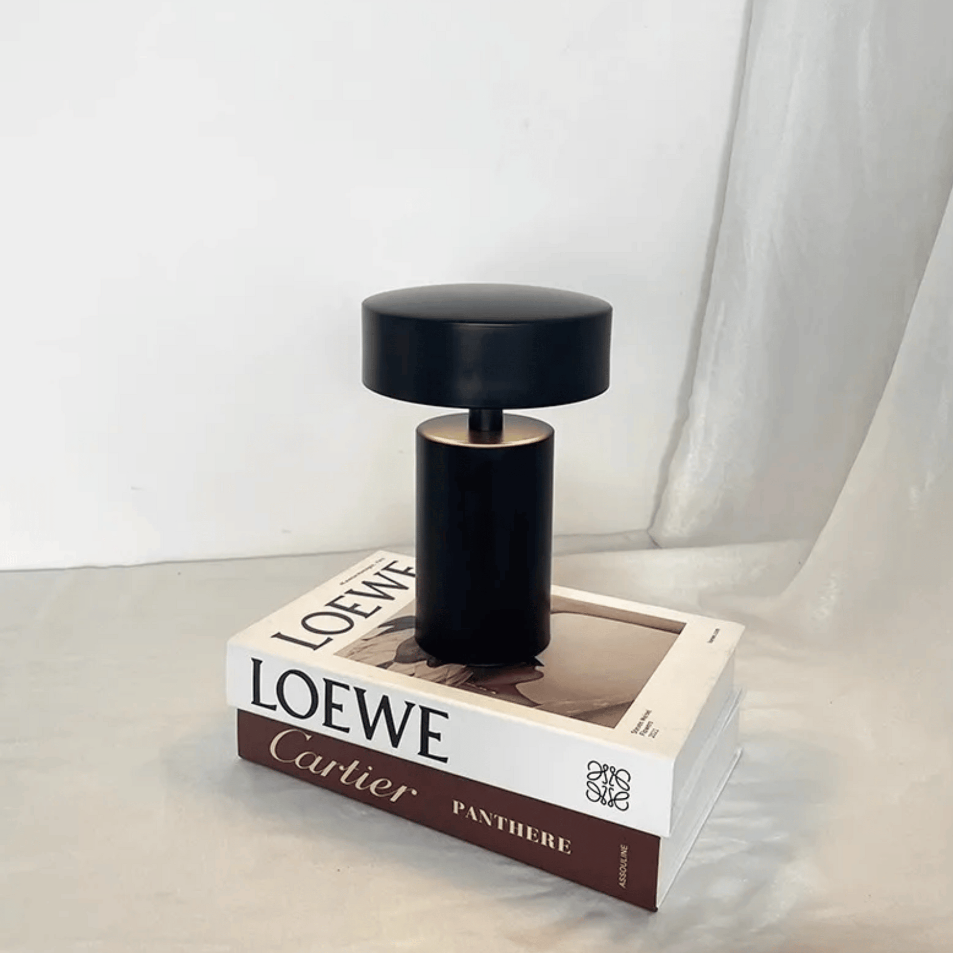 Black perfume bottle on a Loewe box with a white background