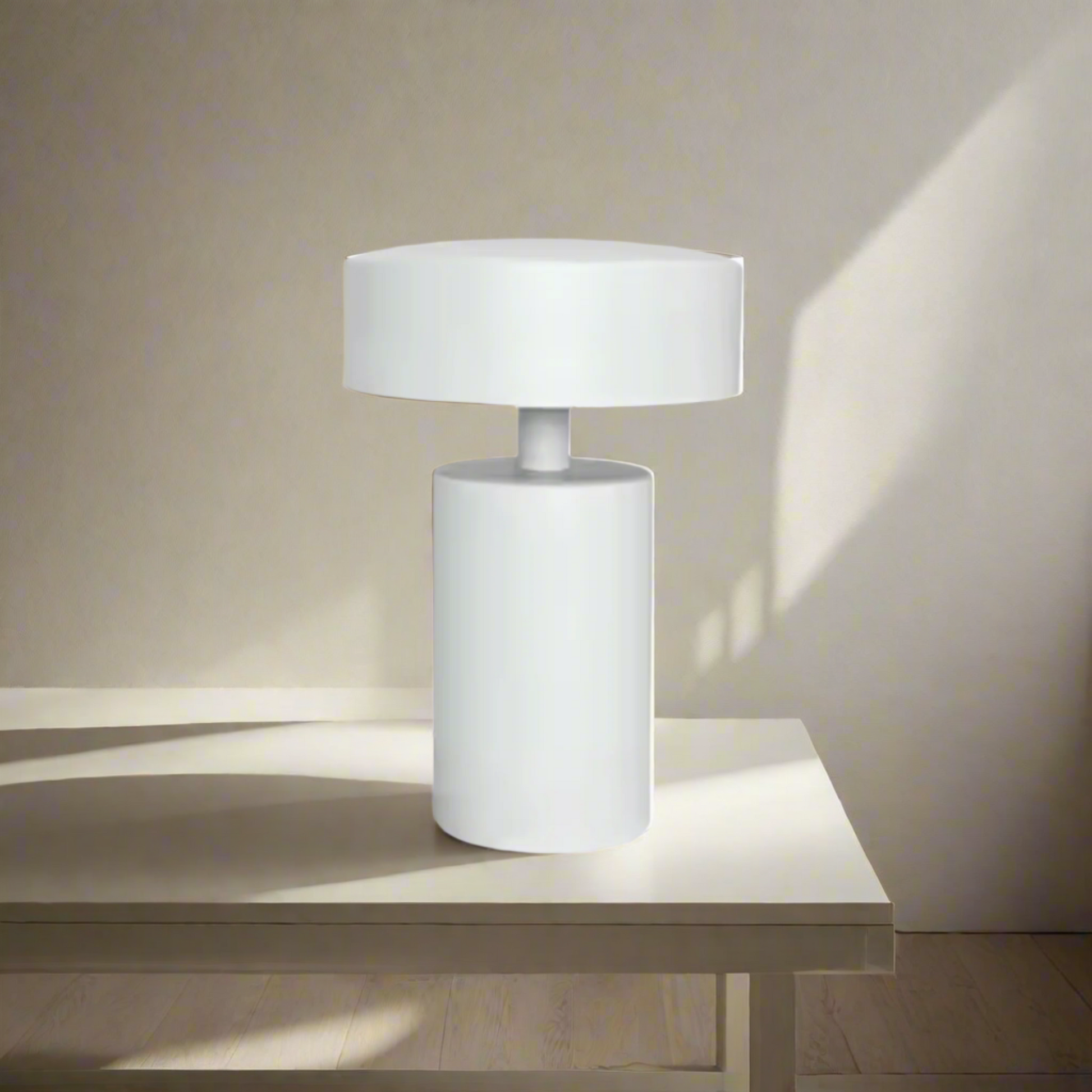 White table lamp with cylindrical base and round shade on a white background