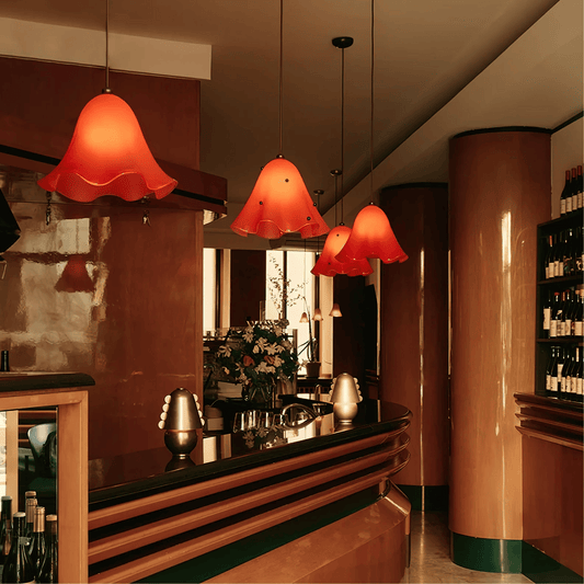 Bar area with red pendant lights, floral arrangement, and bottles.