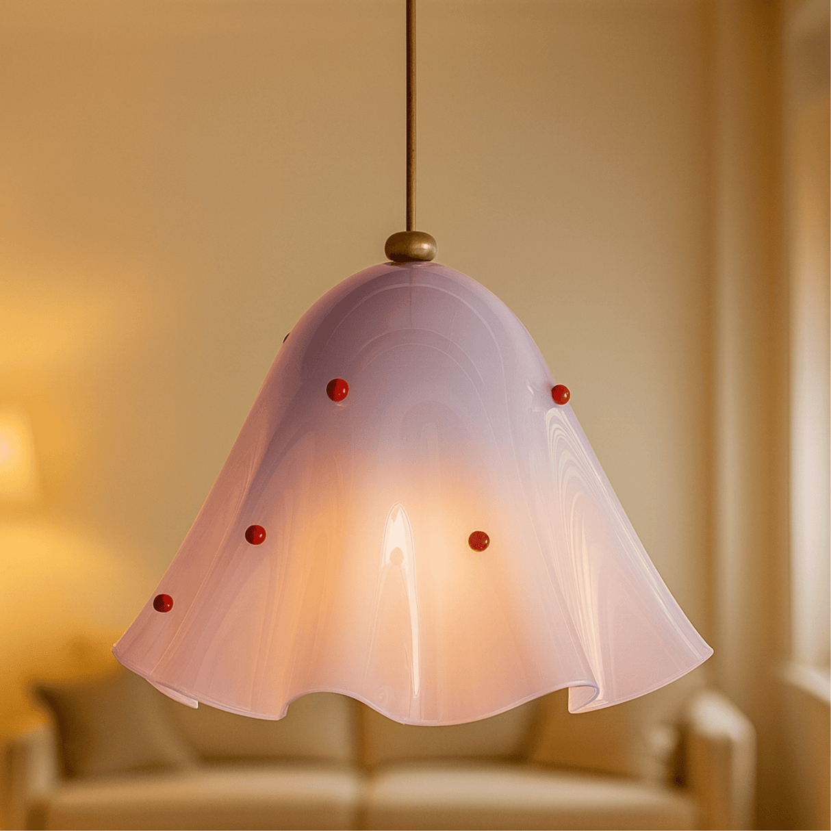 Pink pendant light with red accents in a softly blurred room setting
