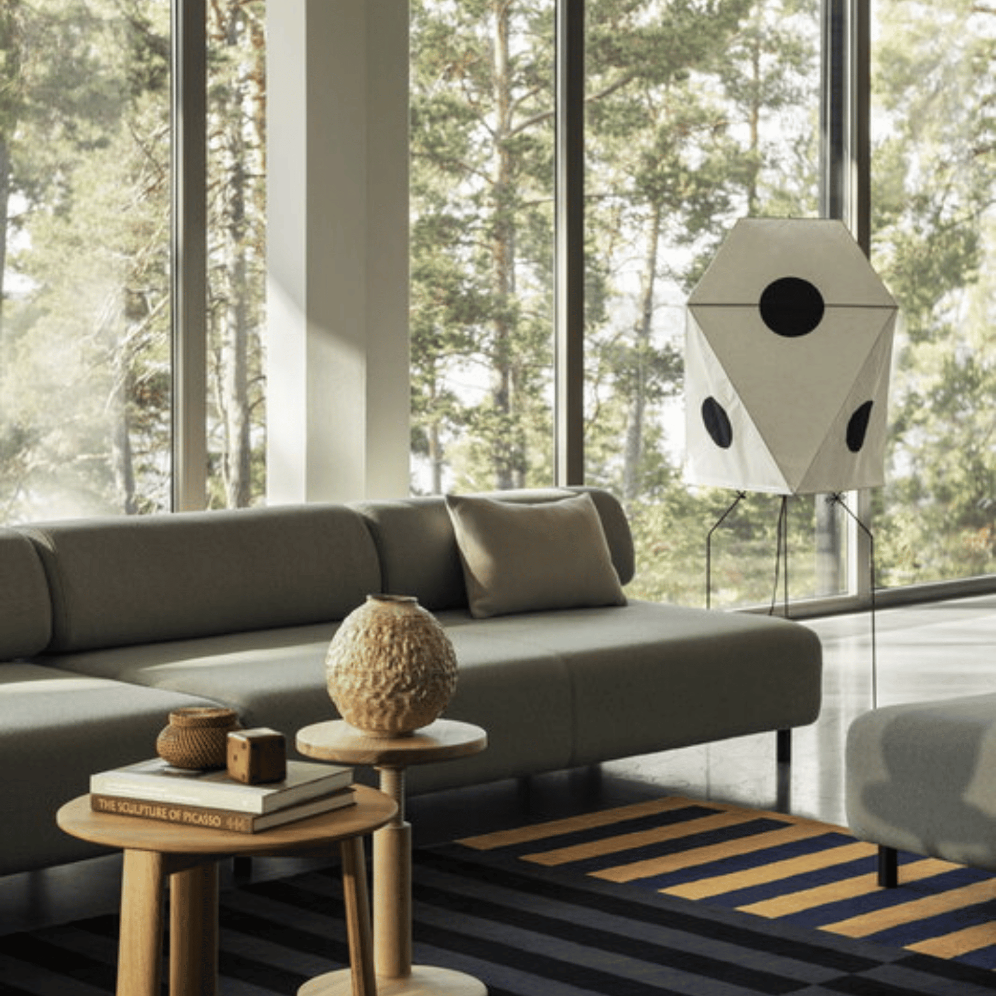 Modern living room with a gray sofa, wooden side table, and decorative items.