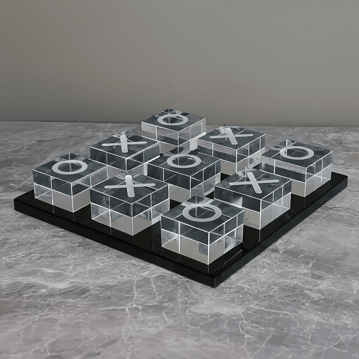 Transparent tic-tac-toe board with Xs and Os on a gray surface