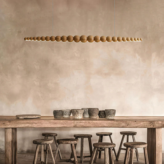A modern kitchen with linear pendant lights hanging above a countertop, offering an elegant and functional light source.