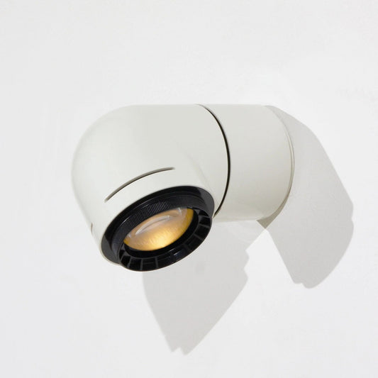 A close-up of a red wall-mounted light fixture, with the light illuminating the wall beneath it.