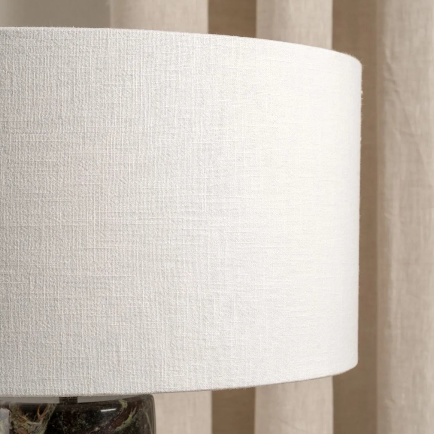 Close-up of a white textured lampshade with a blurred background