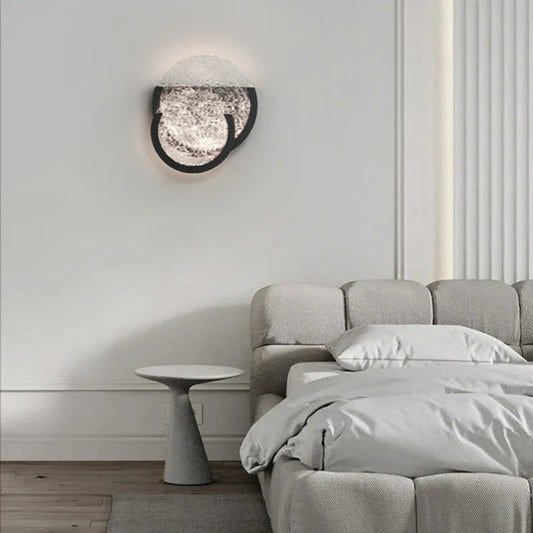 Bedroom wall light with overlapping textured glass circles, adding a soft ambient glow to the room.