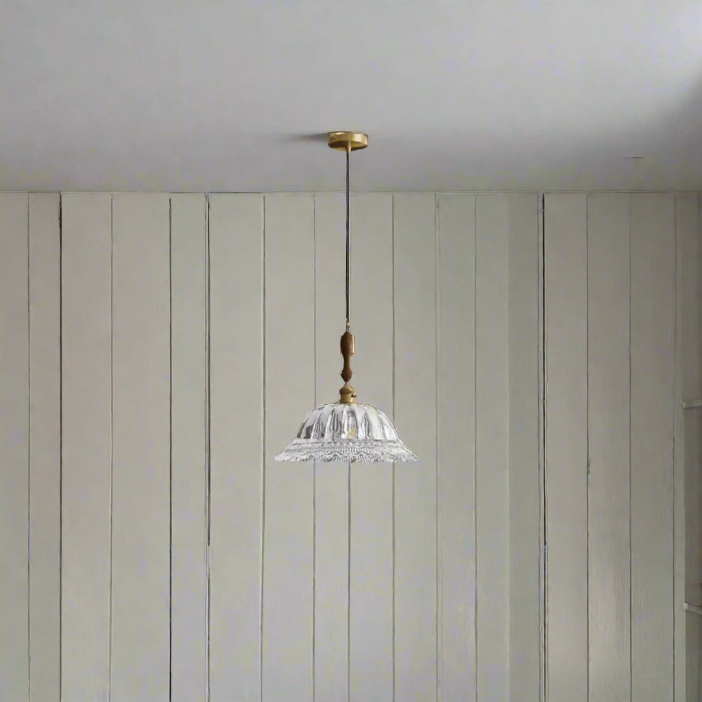 Pendant light with crystal shade and gold fixture on a beige background