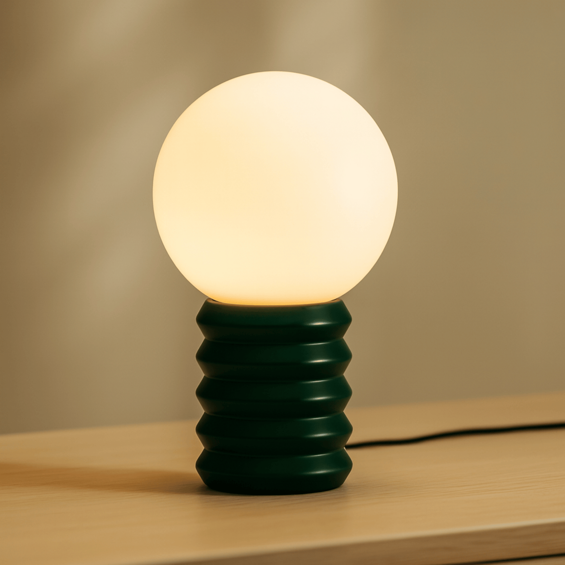 Table lamp with a green base and white bulb on a wooden surface