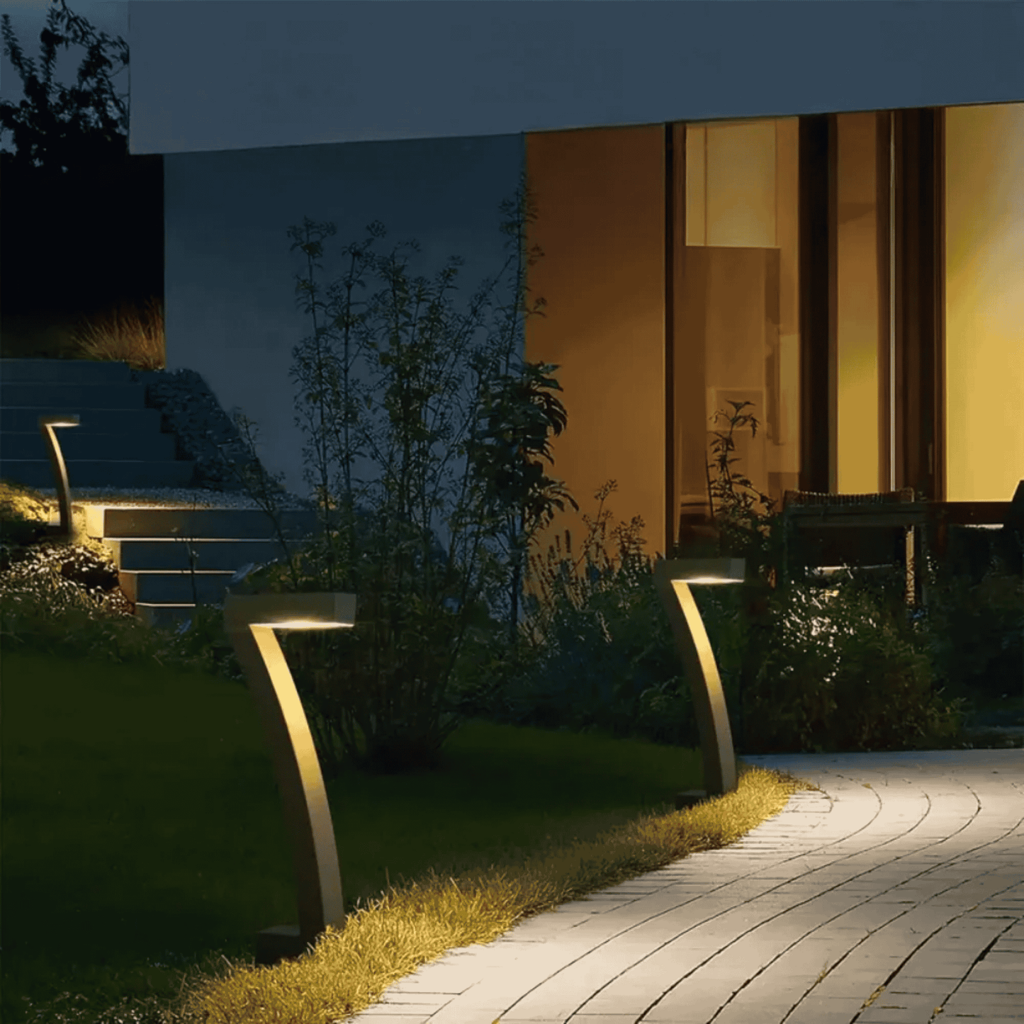 Garden pathway with modern outdoor lights and a building in the background