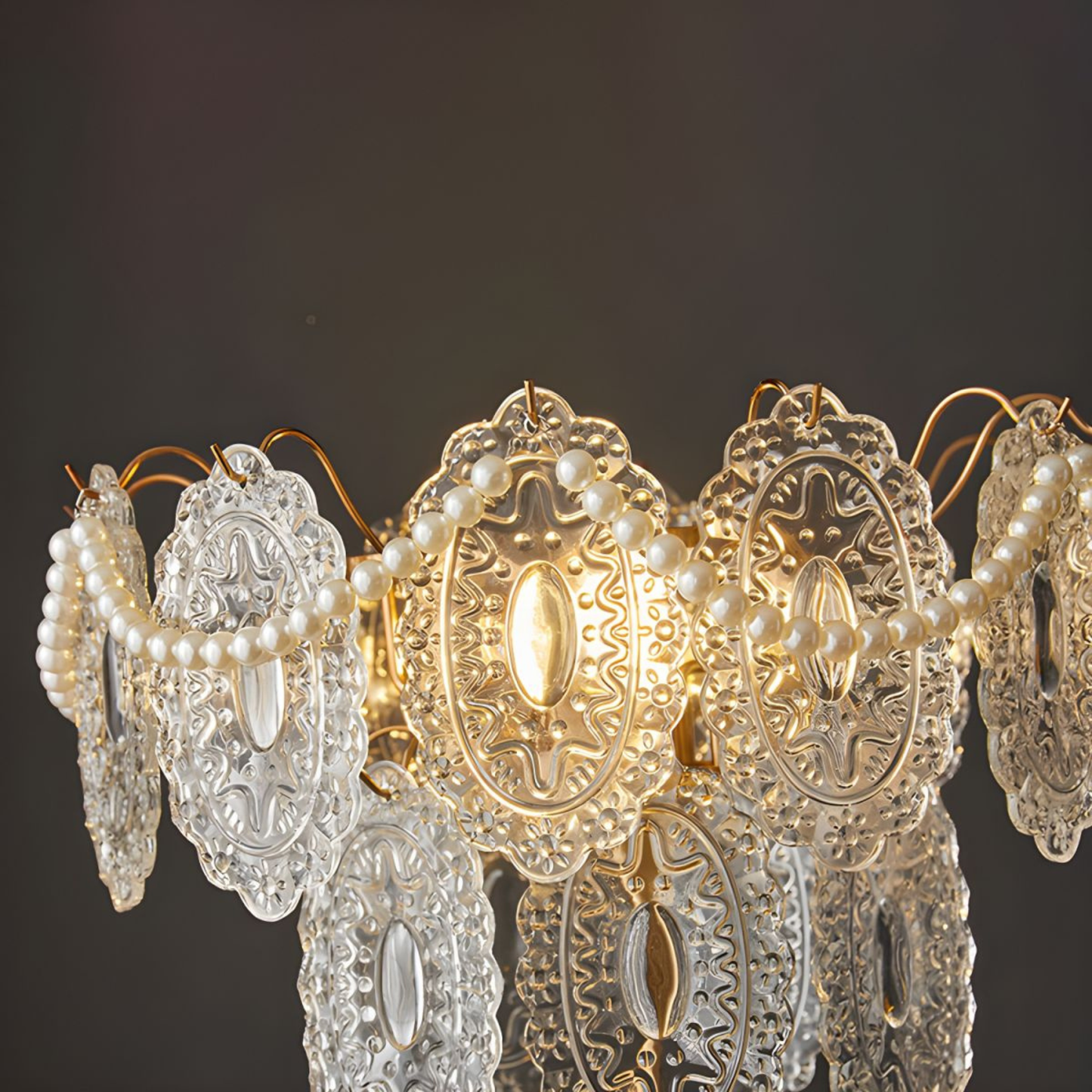 A close-up view of a chandelier-style lamp with intricate crystal details, glowing softly against a dark background.