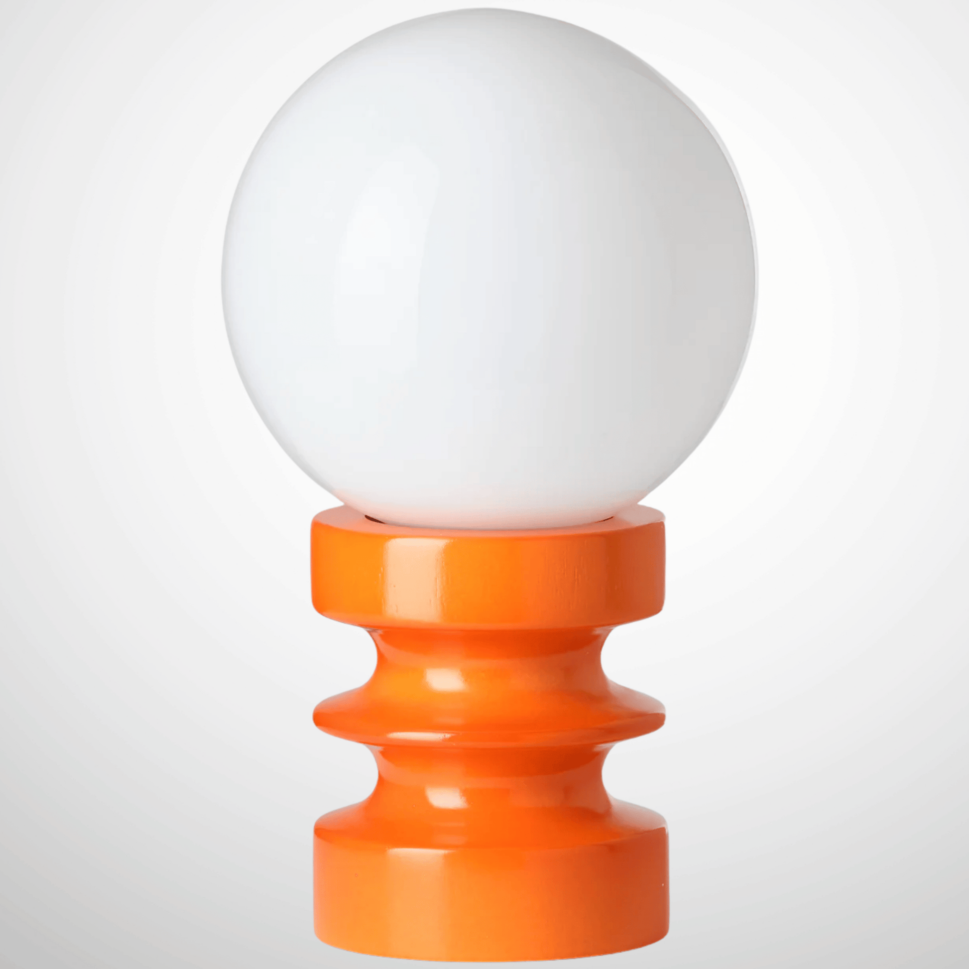 White spherical object on an orange cylindrical stand against a white background