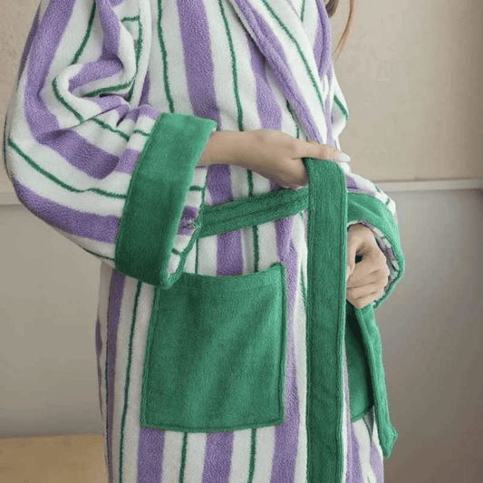 Person wearing a green and purple striped robe with a pocket.