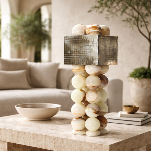 Decorative lamp with stacked spherical design on a coffee table in a living room setting.