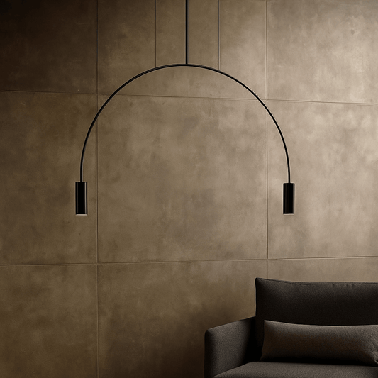 Modern black pendant light against a brown tiled wall with a dark sofa.