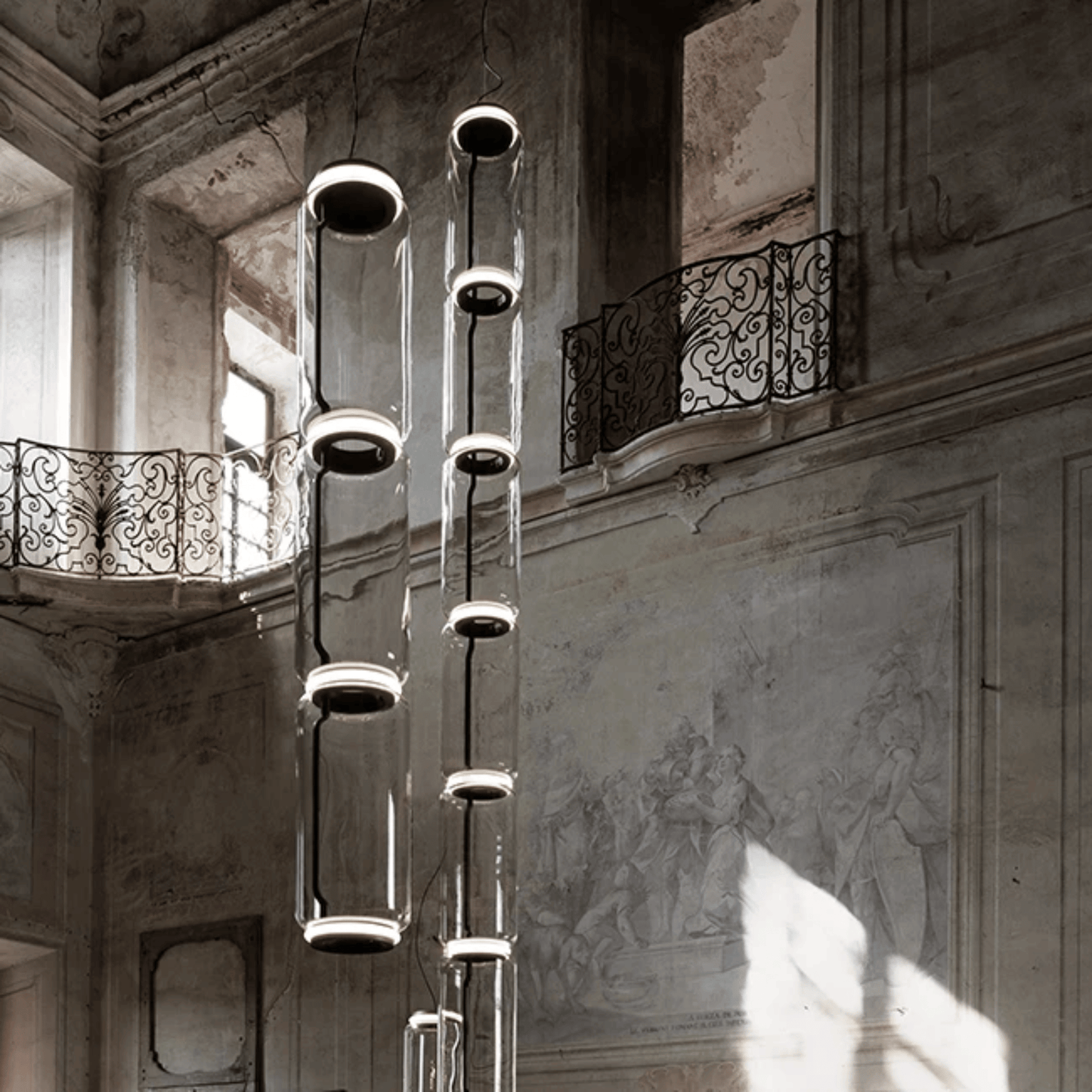 Modern chandelier hanging in an elegant interior setting with architectural details.