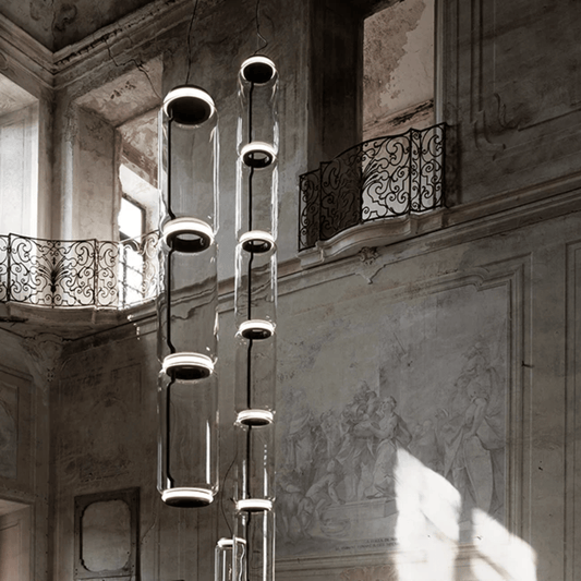 Modern chandelier hanging in an elegant interior setting with architectural details.