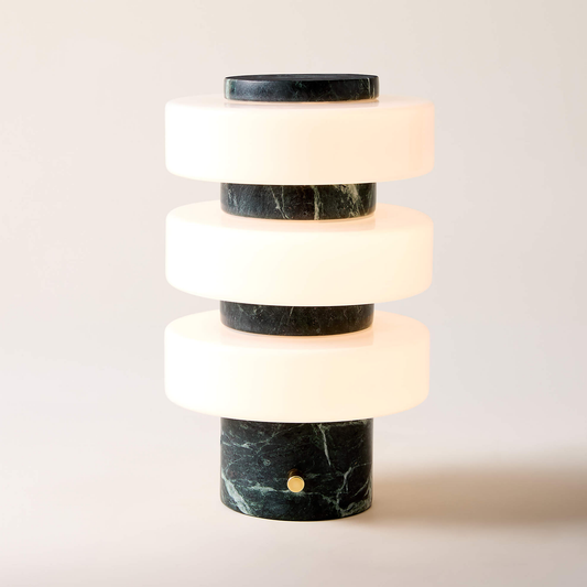 Marble cylindrical table lamp with stacked white and black sections on a light background