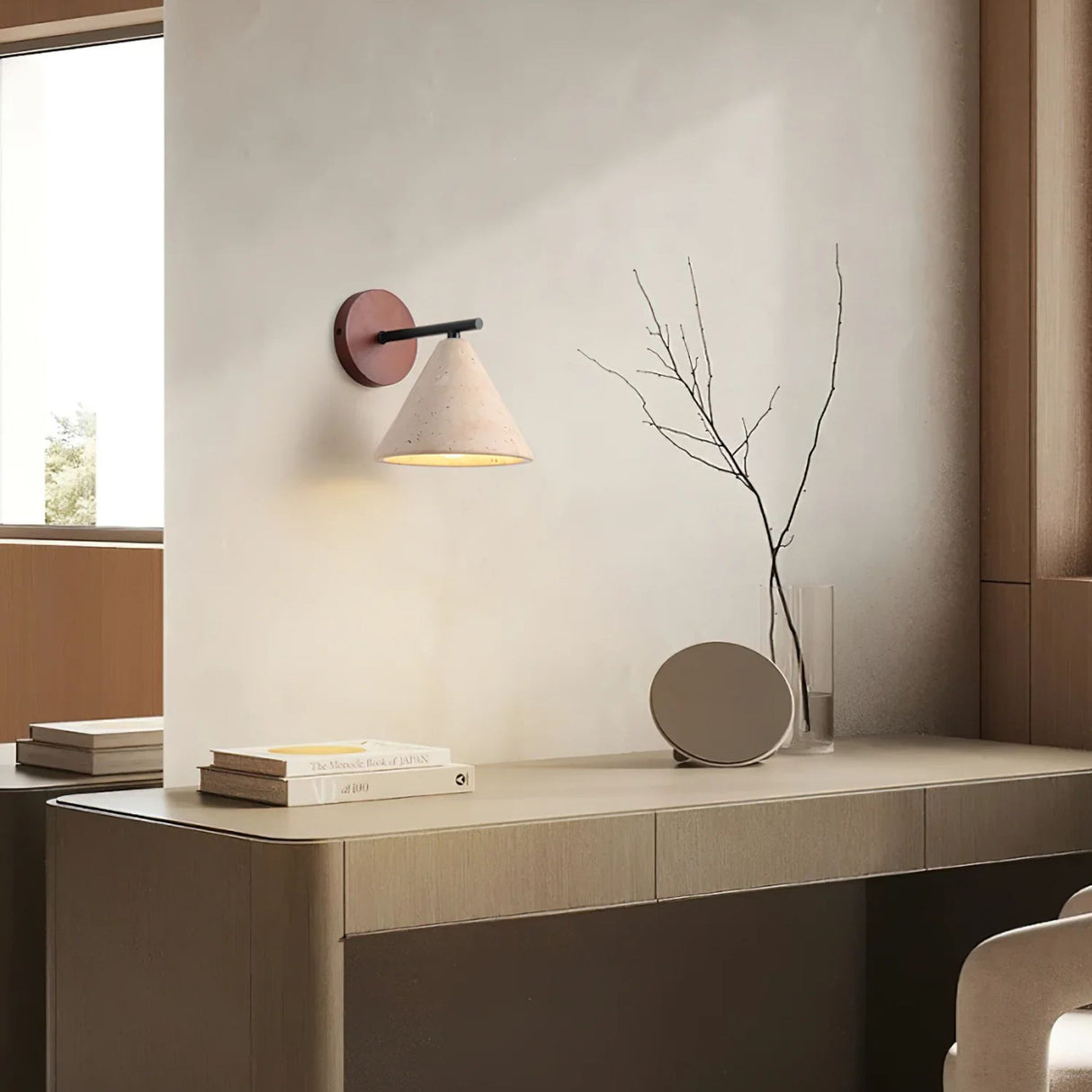 A modern wood-and-white wall sconce mounted above a sleek beige vanity shelf with minimalist decor.
