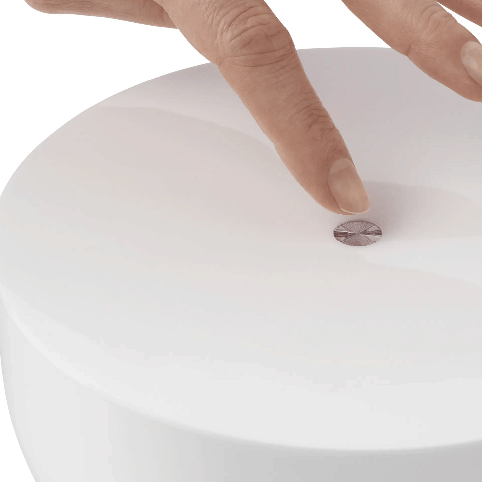 Close-up of a hand pressing a button on a white surface
