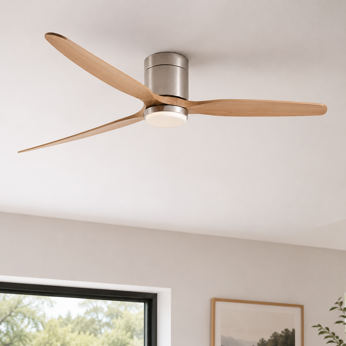 Ceiling fan with wooden blades and metallic finish in a room with a window and wall art.