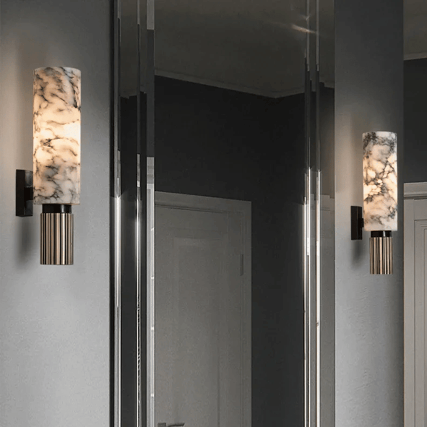 Pair of wall sconces with marble-like finish on a gray wall.