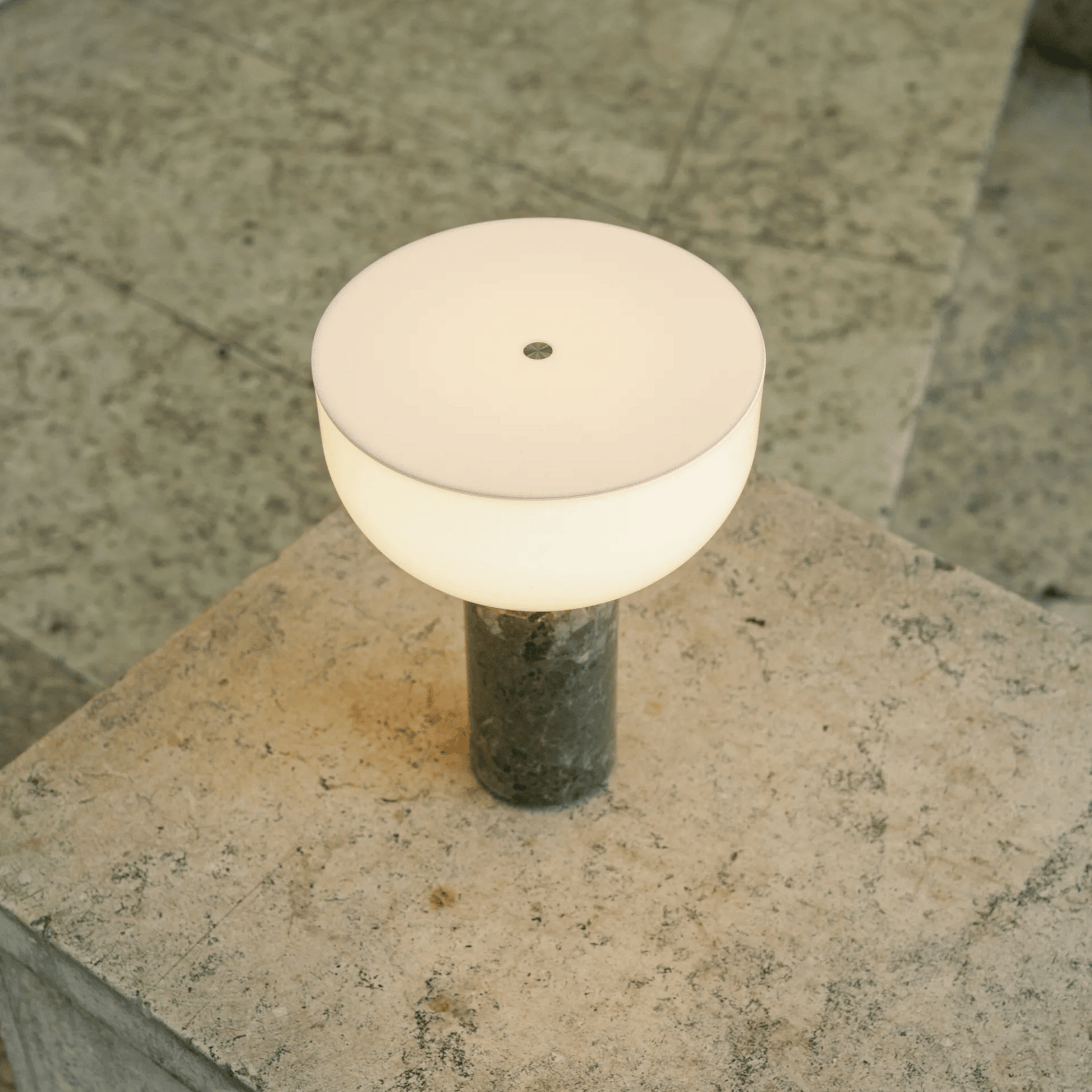 Round outdoor light fixture on a stone surface