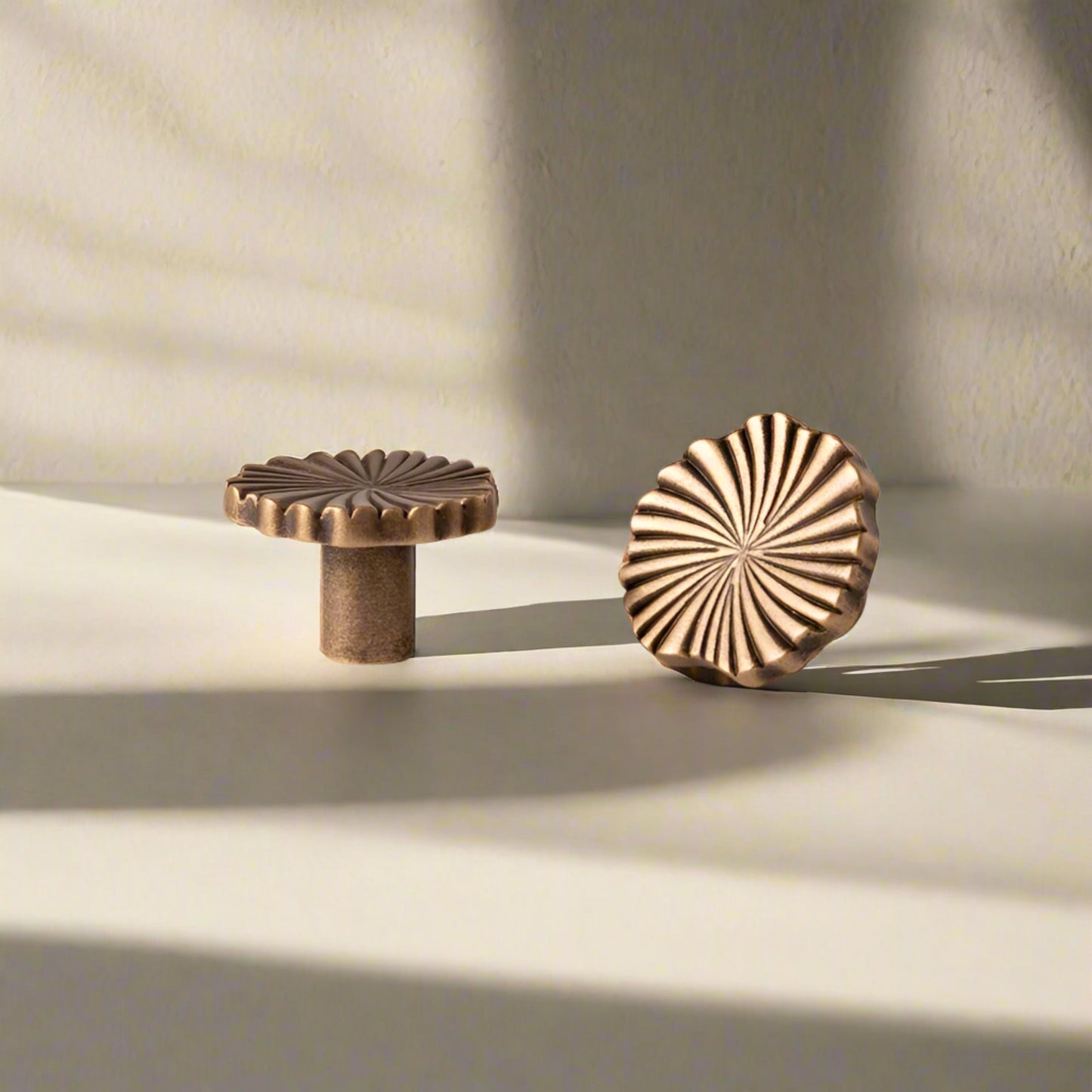 Two solid brass knobs with measurements on a beige background