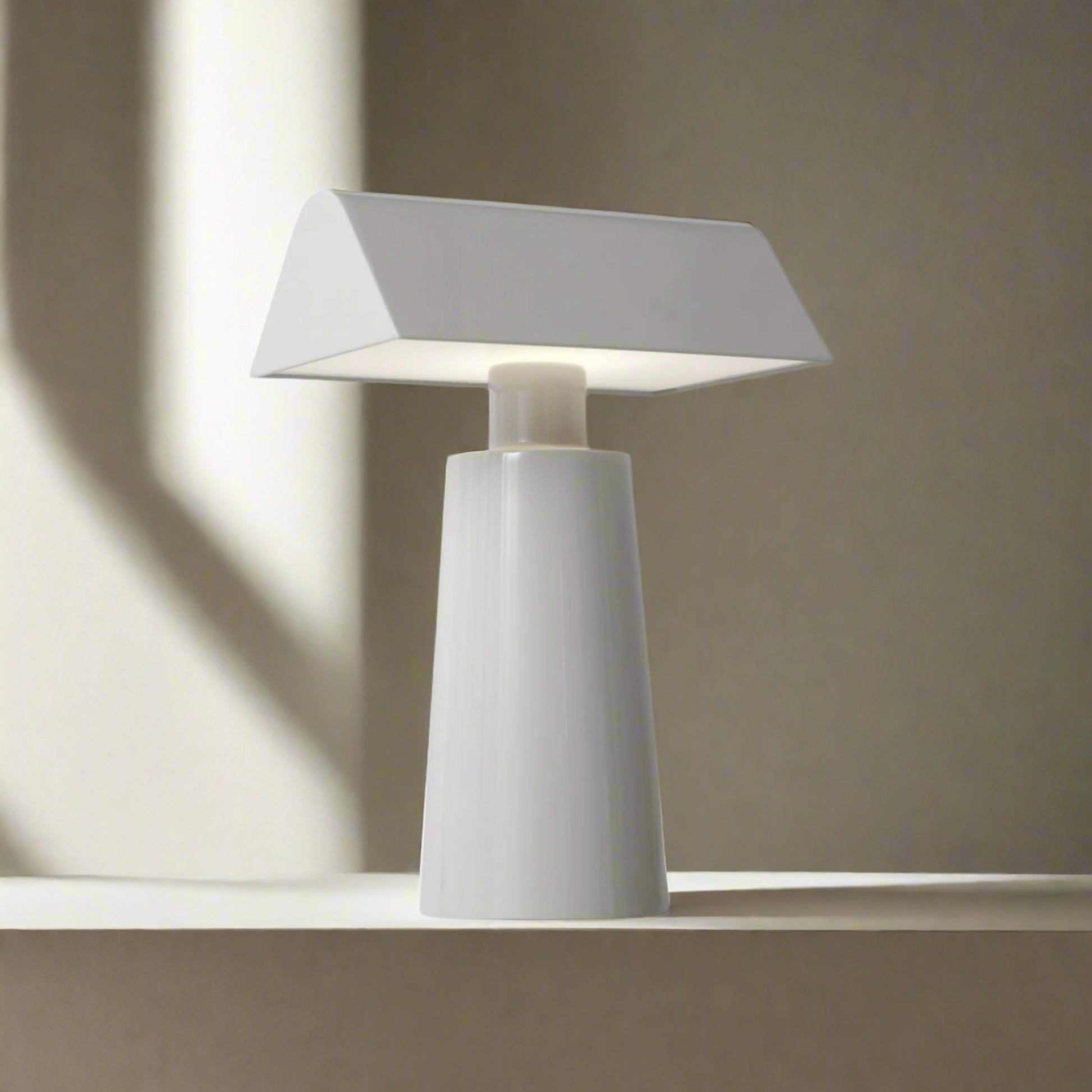 Modern table lamp with a white base and gray shade on a white background