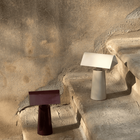 Two modern table lamps on a textured stone surface