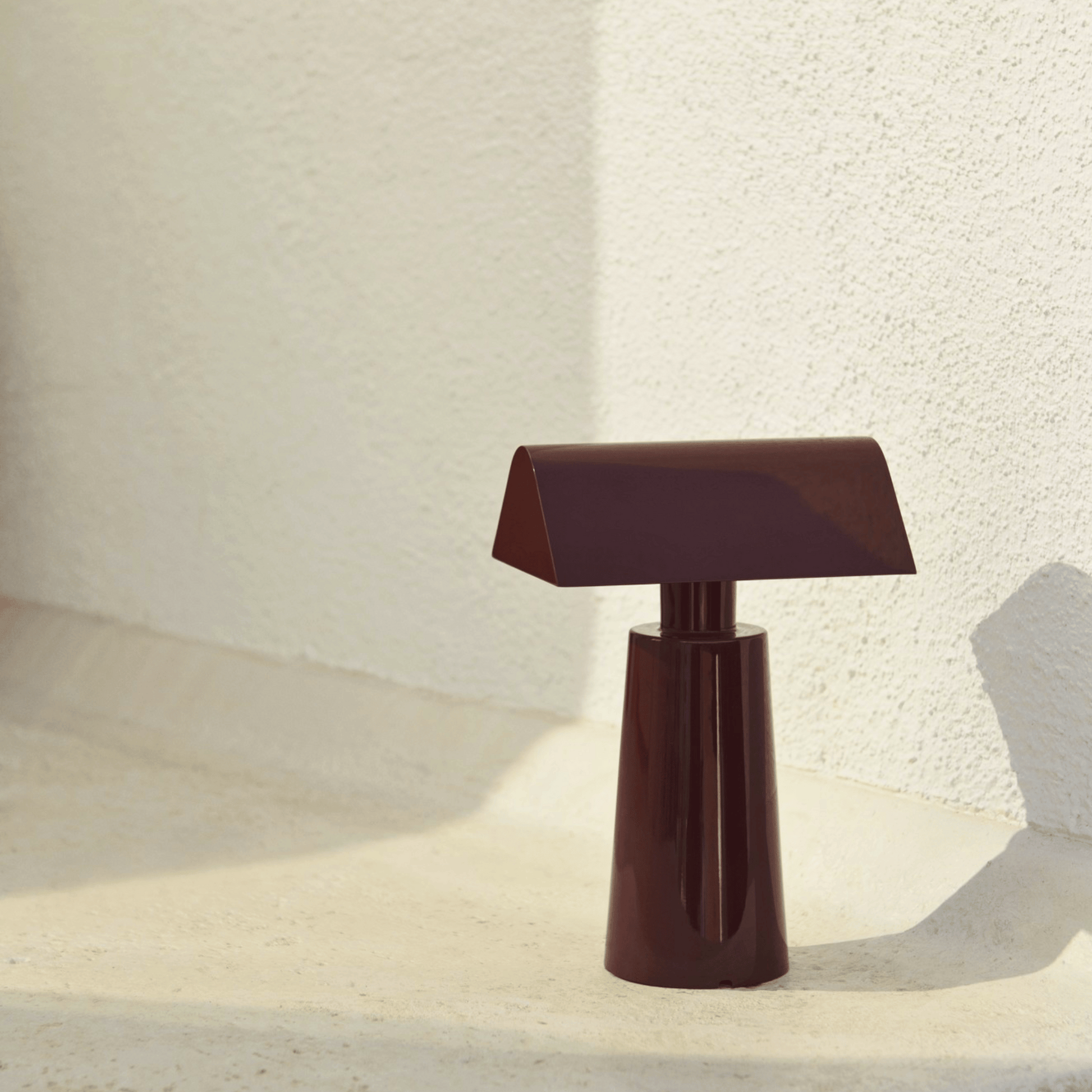 Brown table lamp on a textured surface with a neutral background