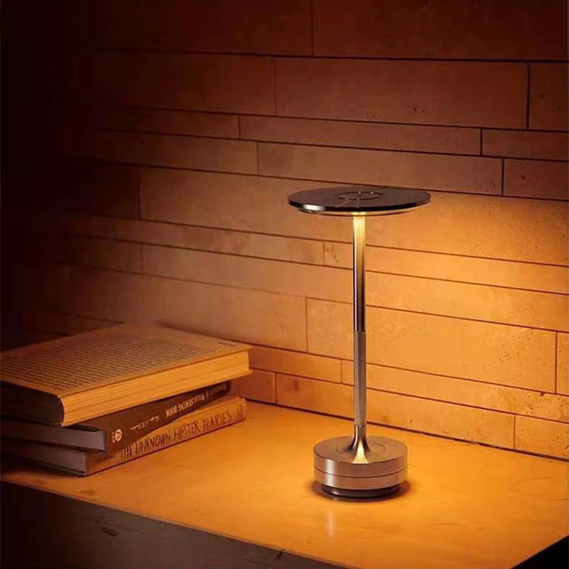 Silver lamp on a wooden surface with books in the background