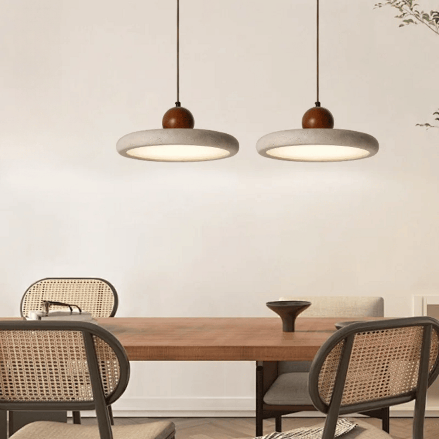 Dining area with wooden table and chairs under two pendant lights.