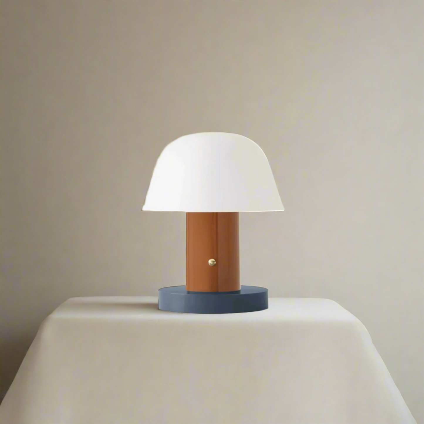 Table lamp with white shade, wooden base, and blue skirt on a beige background